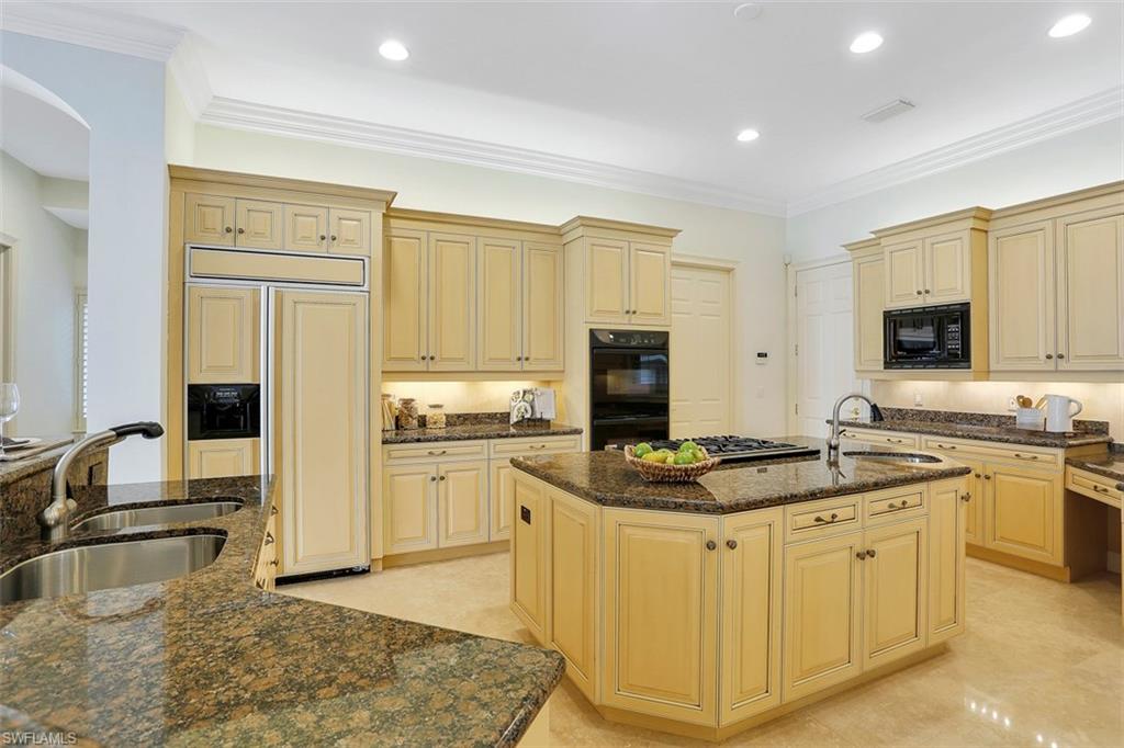 2050 Kingfish Road Naples, FL 34102 - Photo 20 of 35 a kitchen with stainless steel appliances granite countertop a sink stove and refrigerator
