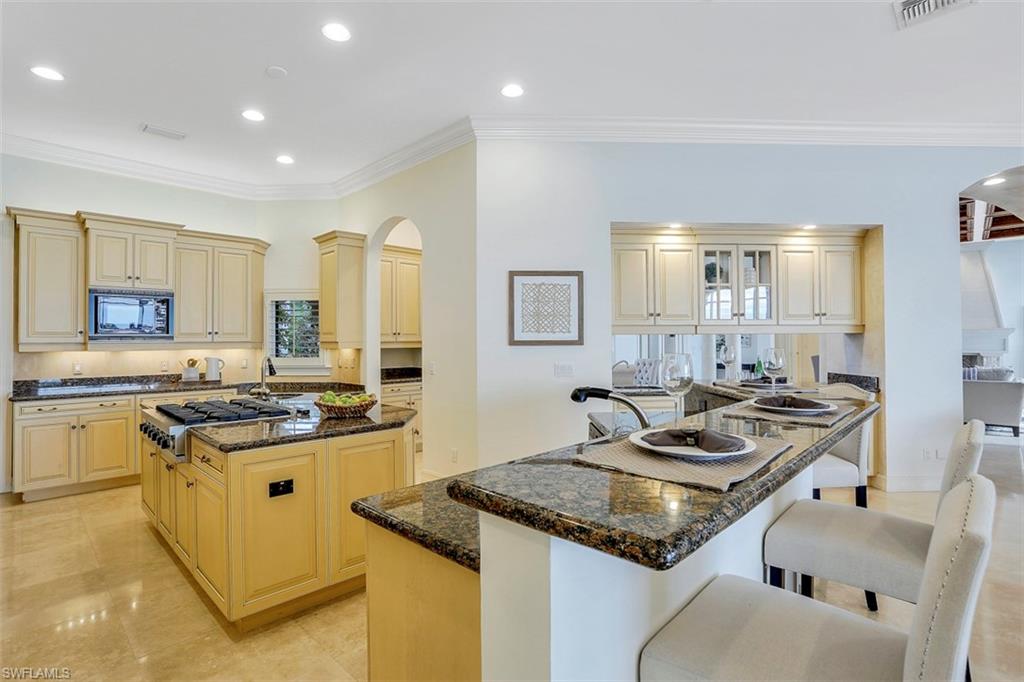 2050 Kingfish Road Naples, FL 34102 - Photo 21 of 35 a kitchen that has a sink a stove and chairs