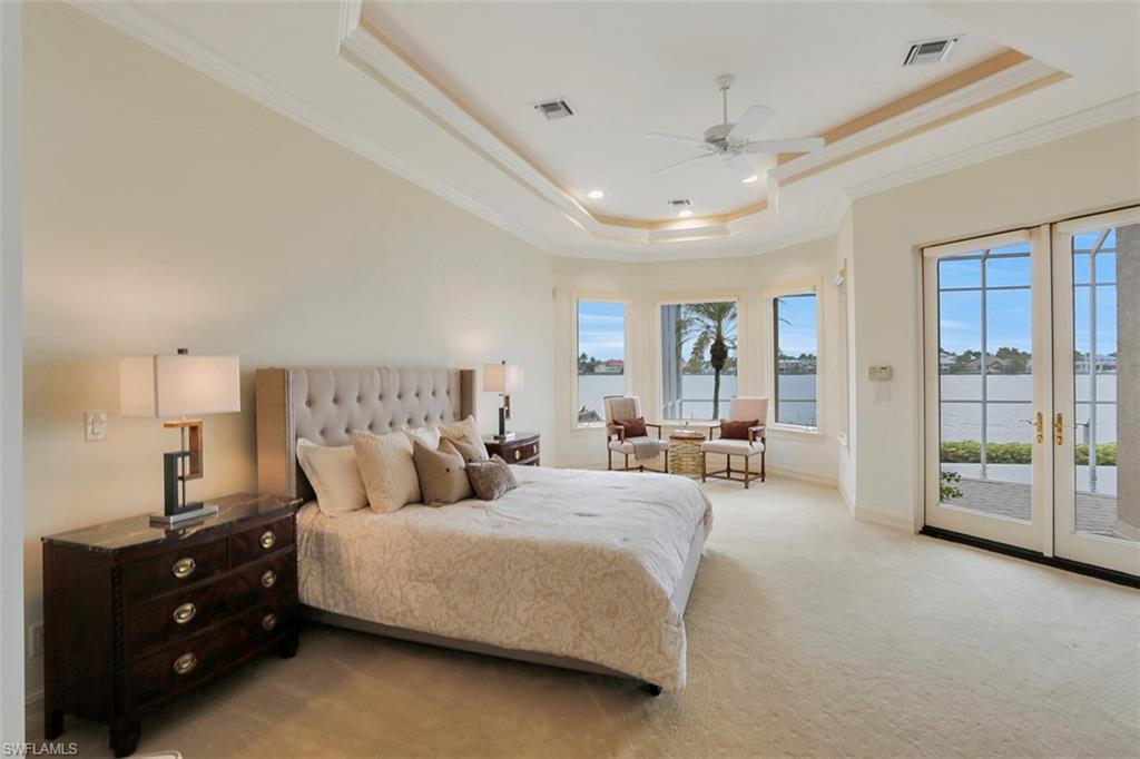 2050 Kingfish Road Naples, FL 34102 - Photo 23 of 35 a spacious bedroom with a bed and glass window