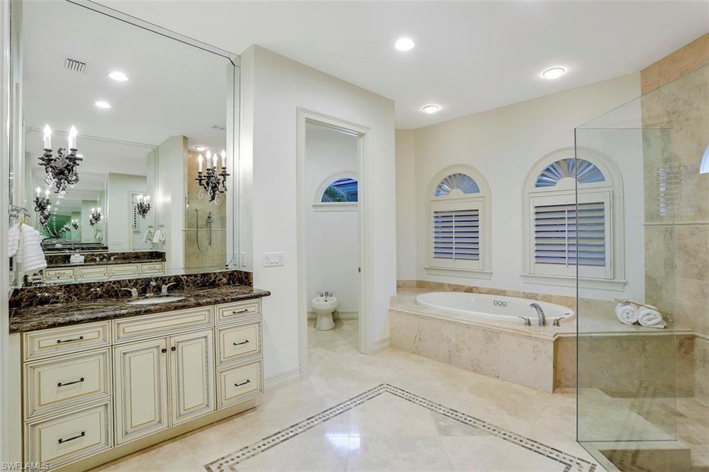 2050 Kingfish Road Naples, FL 34102 - Photo 25 of 35 a spacious bathroom with double vanity a mirror a bathtub and a shower