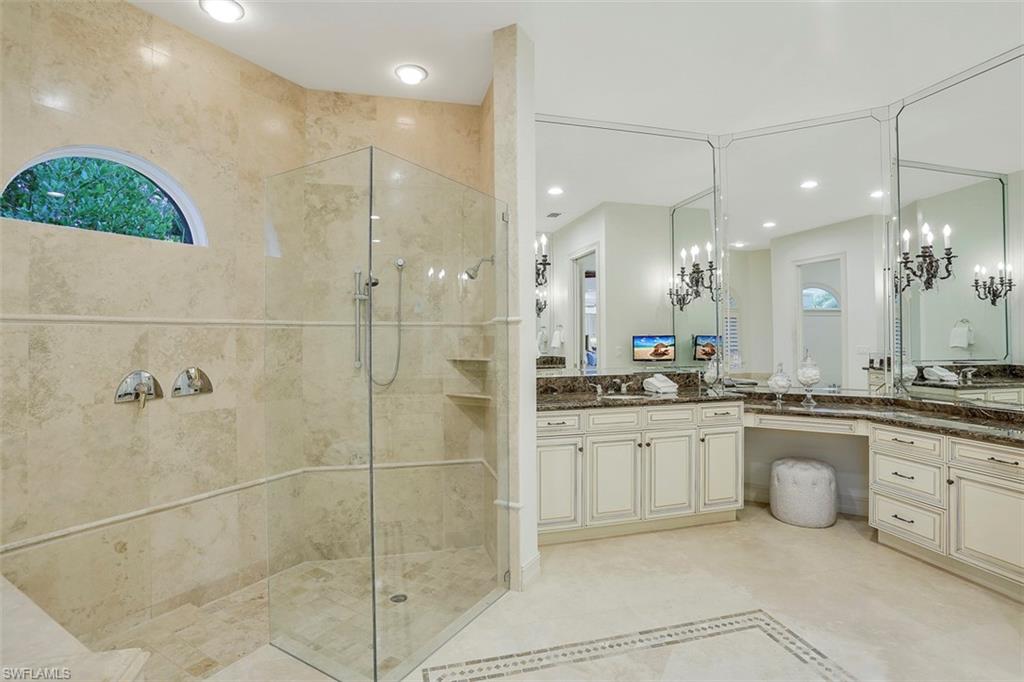 2050 Kingfish Road Naples, FL 34102 - Photo 26 of 35 a bathroom with a granite countertop sink a large mirror and shower