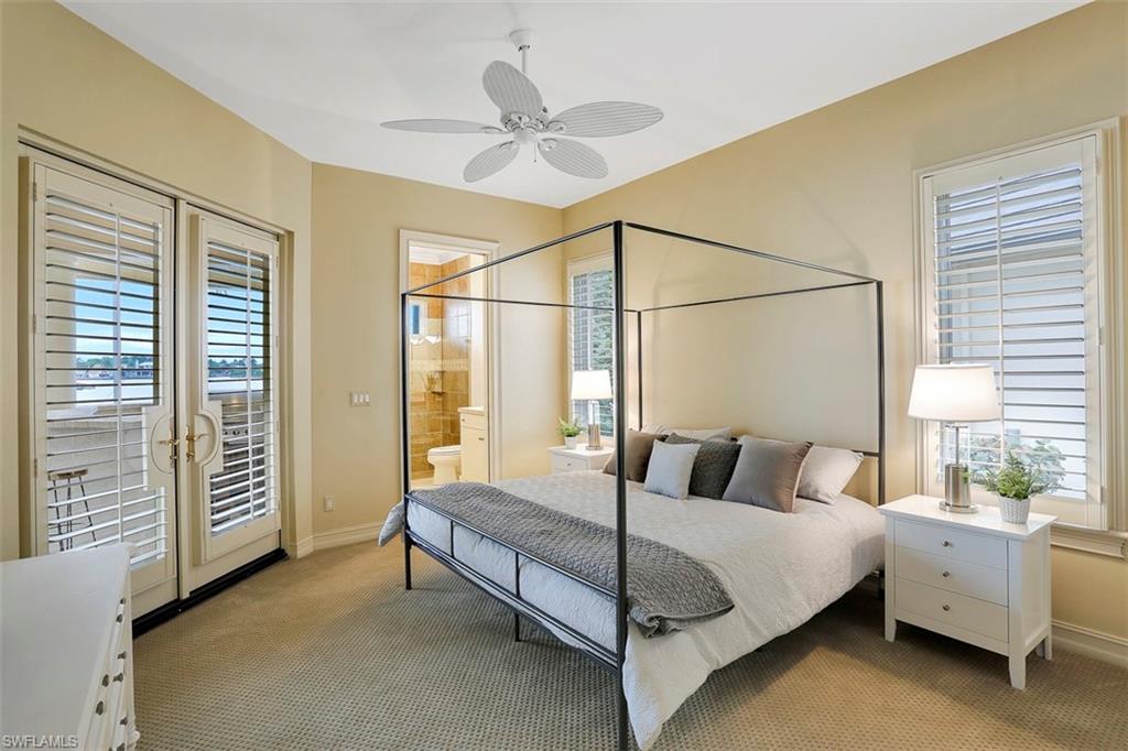 2050 Kingfish Road Naples, FL 34102 - Photo 27 of 35 a bedroom with a bed and a chandelier