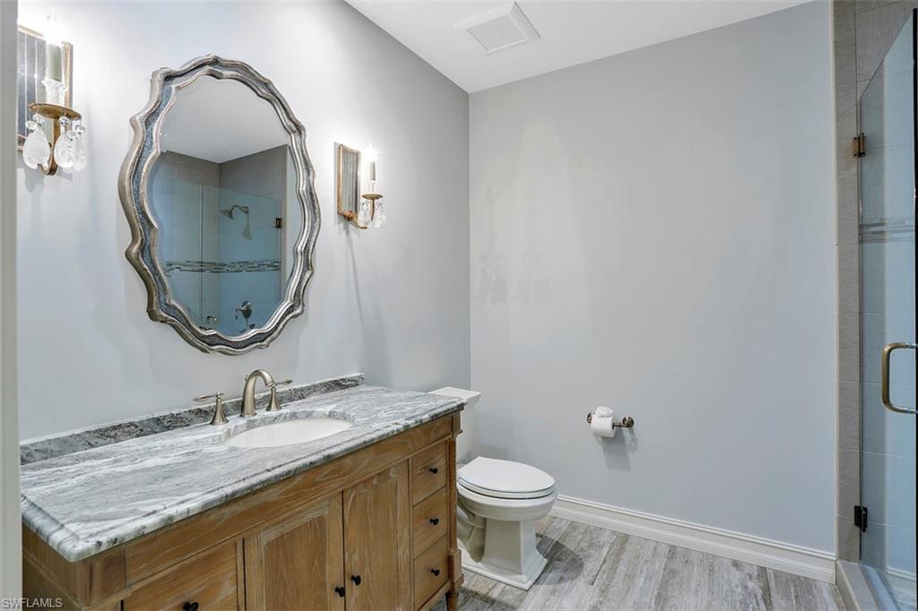 2050 Kingfish Road Naples, FL 34102 - Photo 33 of 35 a bathroom with a granite countertop toilet sink and mirror