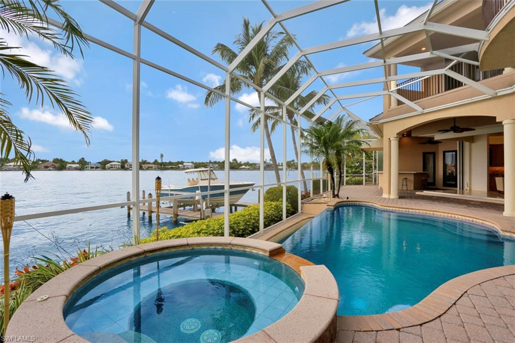 2050 Kingfish Road Naples, FL 34102 - Photo 7 of 35 a swimming pool with outdoor seating and yard