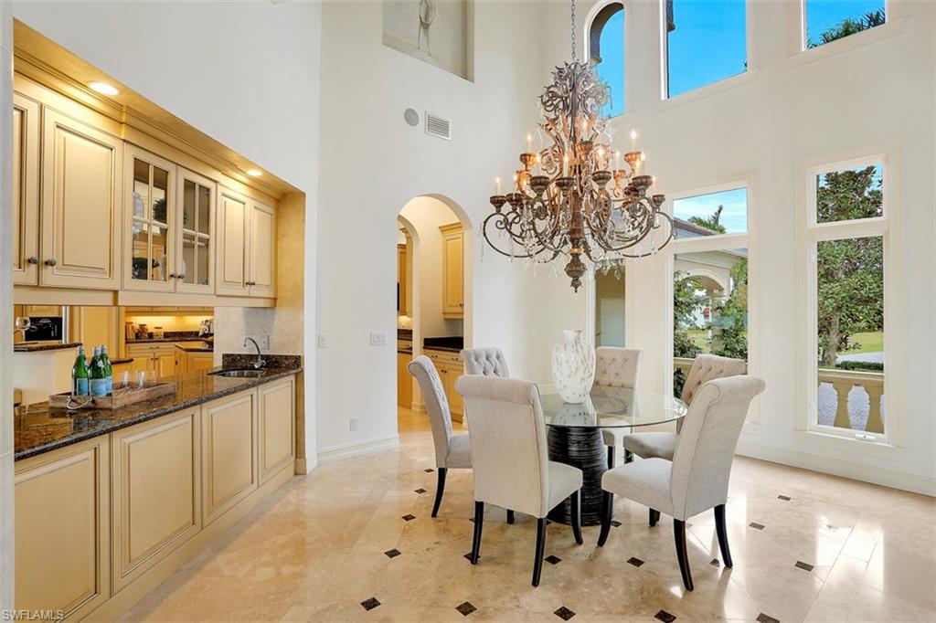 2050 Kingfish Road Naples, FL 34102 - Photo 8 of 35 a view of a dining room with furniture a chandelier and wooden floor