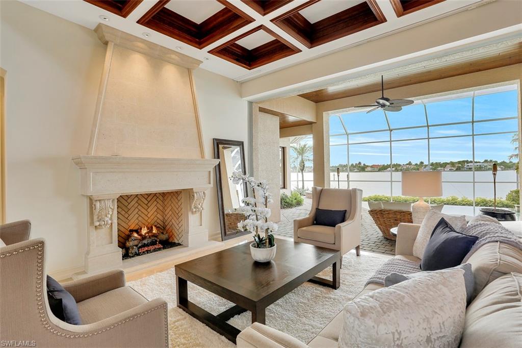2050 Kingfish Road Naples, FL 34102 - Photo 9 of 35 a living room with furniture a fireplace and a ceiling fan