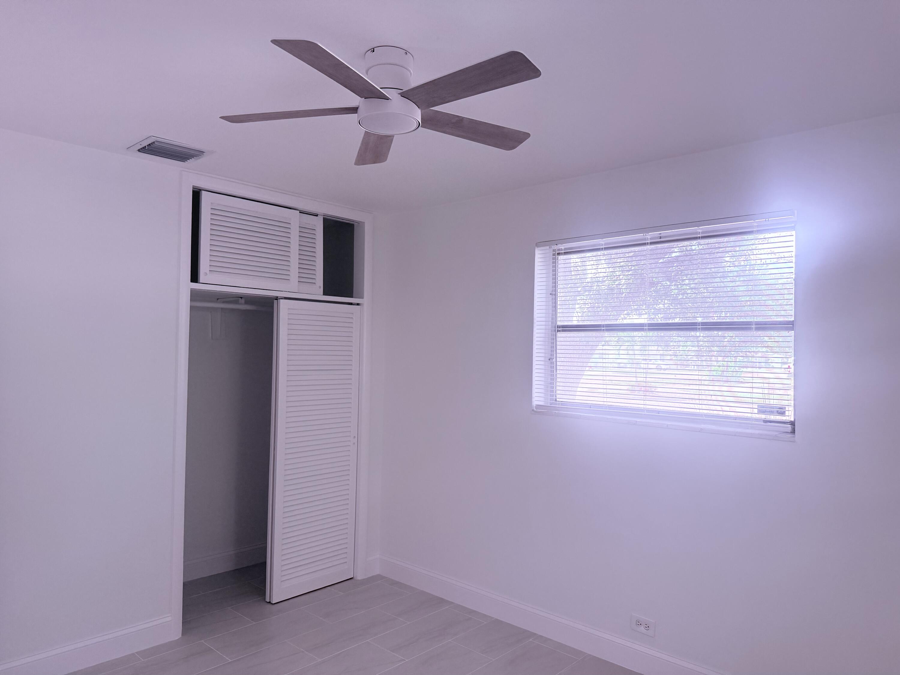 630 Prosperity Farms Road, Unit 1 North Palm Beach, FL 33408 - Photo 15 of 16 an empty room with a ceiling fan and a window