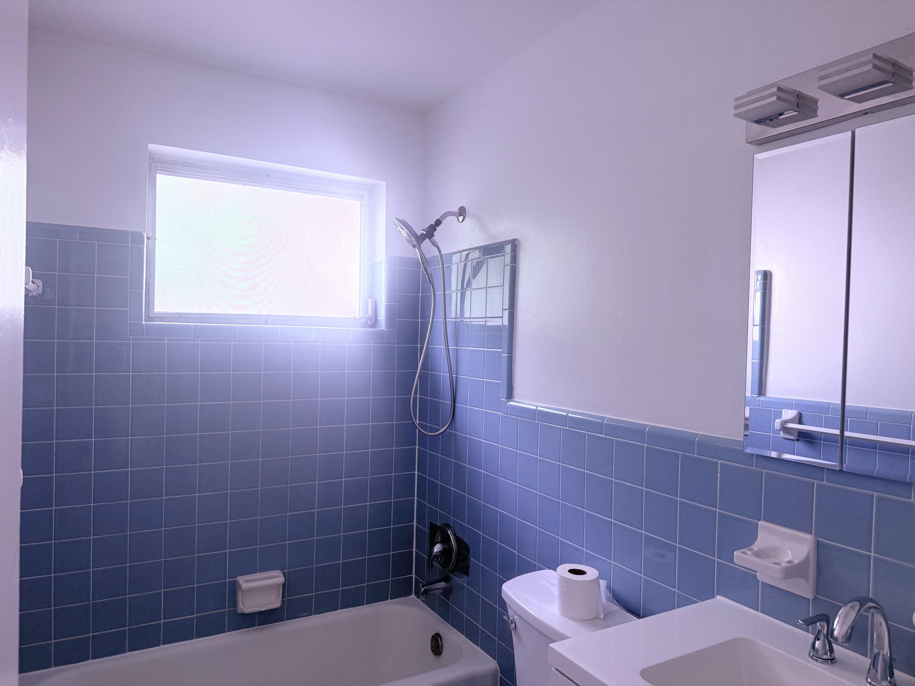 630 Prosperity Farms Road, Unit 1 North Palm Beach, FL 33408 - Photo 16 of 16 a bathroom with a toilet sink and mirror