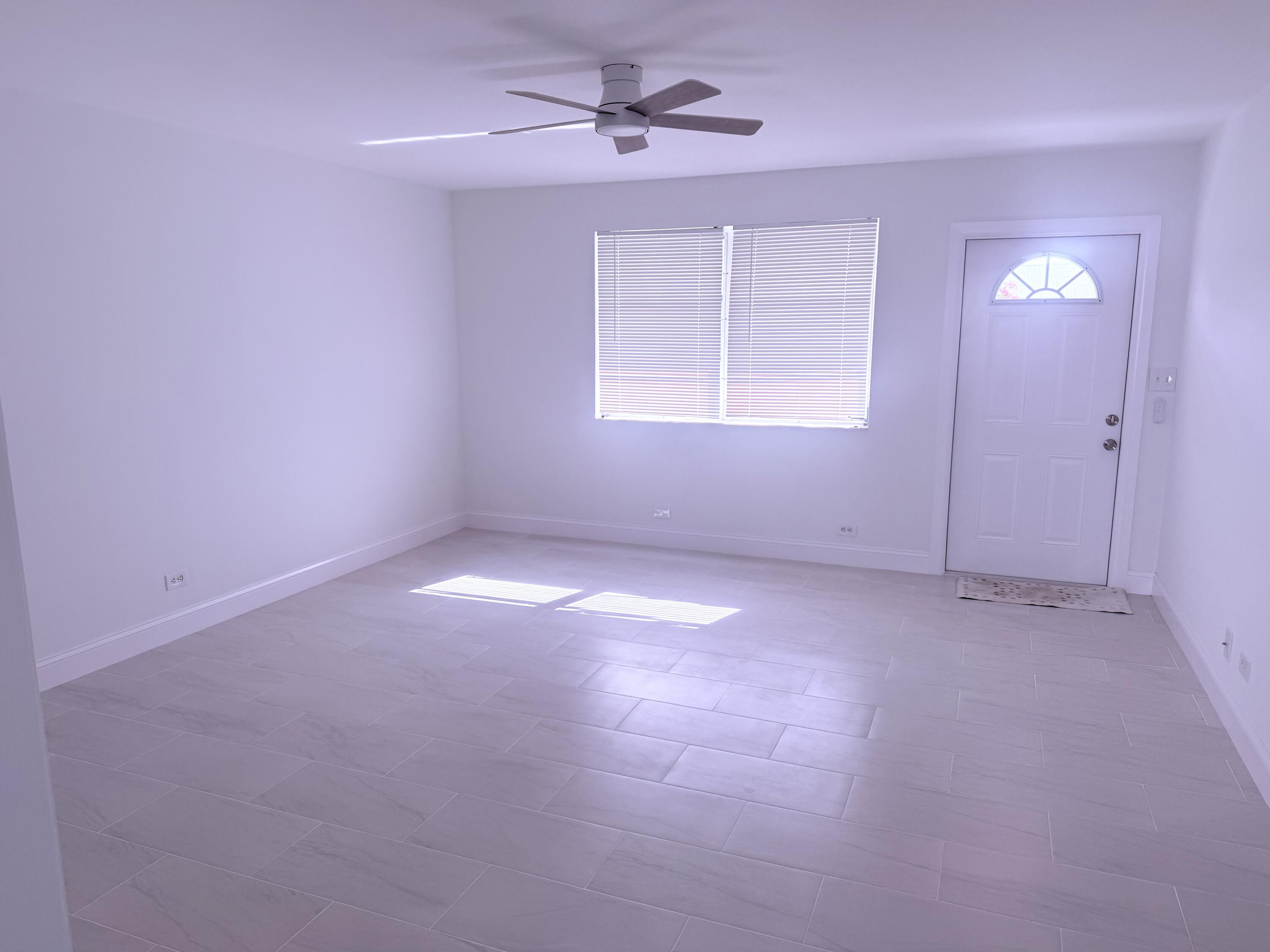 630 Prosperity Farms Road, Unit 1 North Palm Beach, FL 33408 - Photo 6 of 16 an empty room with windows and fan