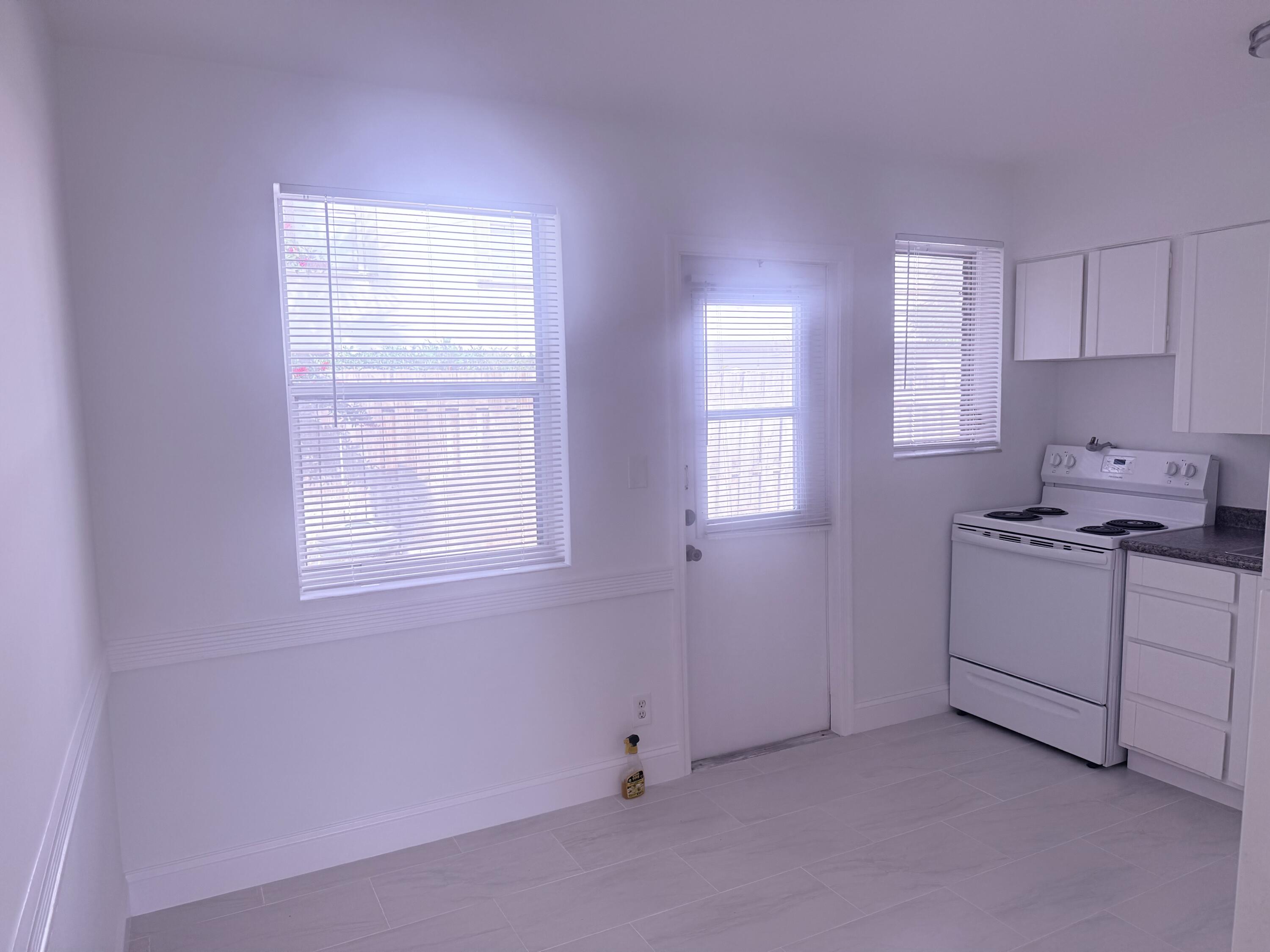 630 Prosperity Farms Road, Unit 1 North Palm Beach, FL 33408 - Photo 9 of 16 a kitchen with white cabinets and white appliances