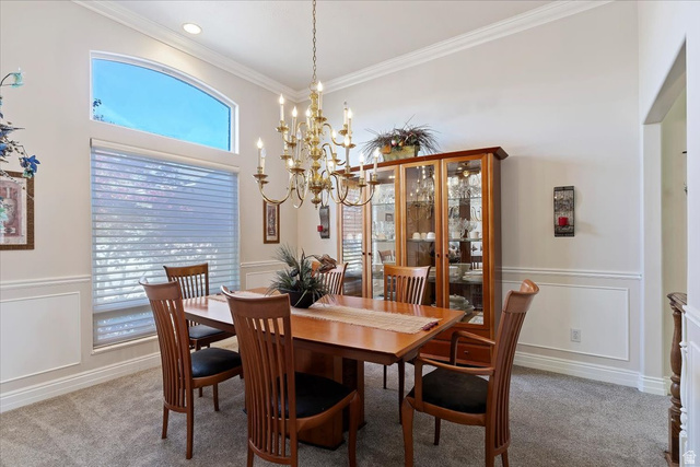 1924 North 2000th Street East Layton, UT 84040 - Photo 10 of 41 Carpeted dining area featuring a decorative wall, a wainscoted wall, crown molding, and a chandelier