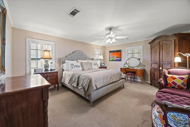 a spacious bedroom with a bed a chandelier and a dresser