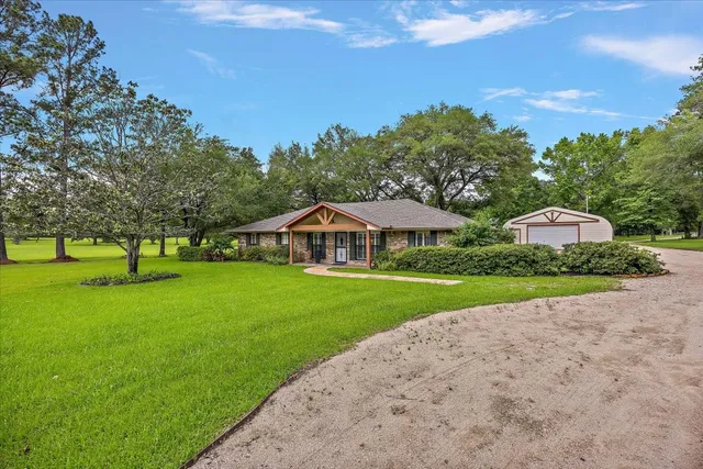 a front view of a house with yard and green space