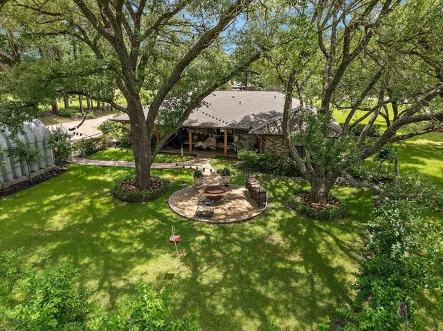 a view of a backyard with table and chairs and a large tree