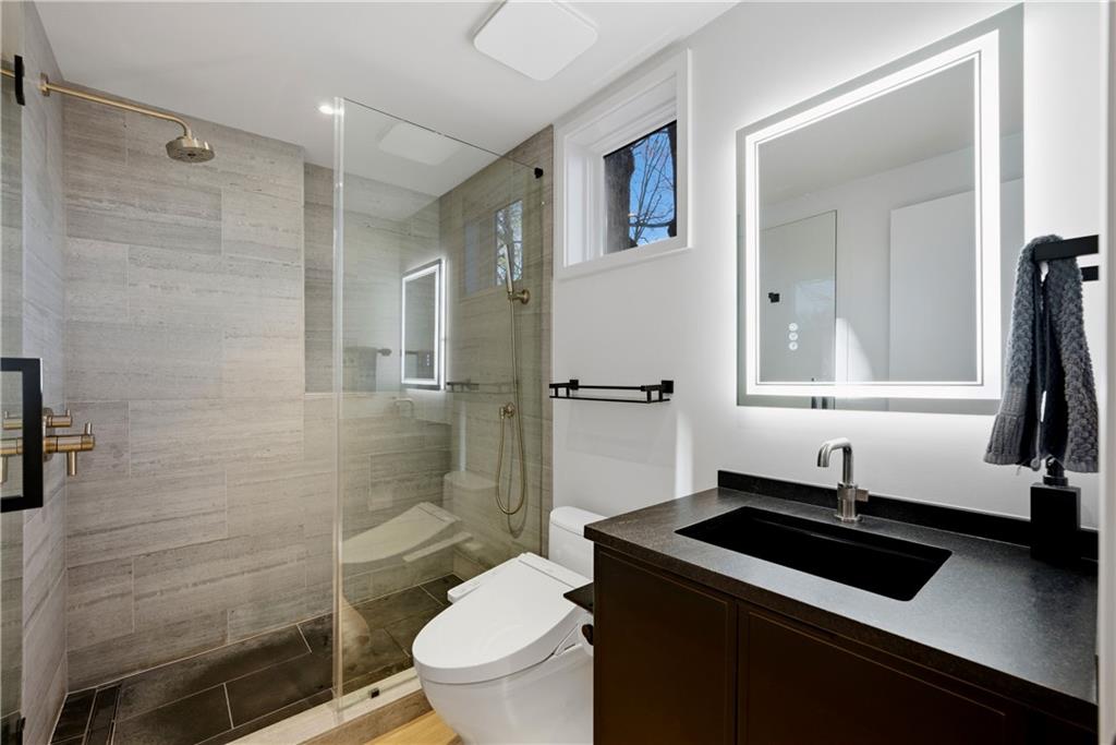 1033 Reeder Circle Northeast Atlanta, GA 30306 - Photo 72 of 77 a bathroom with a sink a toilet a mirror and shower