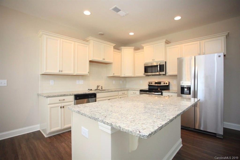5326 Roberta Road Concord, NC 28027 - Photo 5 of 6 a kitchen with granite countertop a refrigerator a sink a stove a microwave and wooden floor