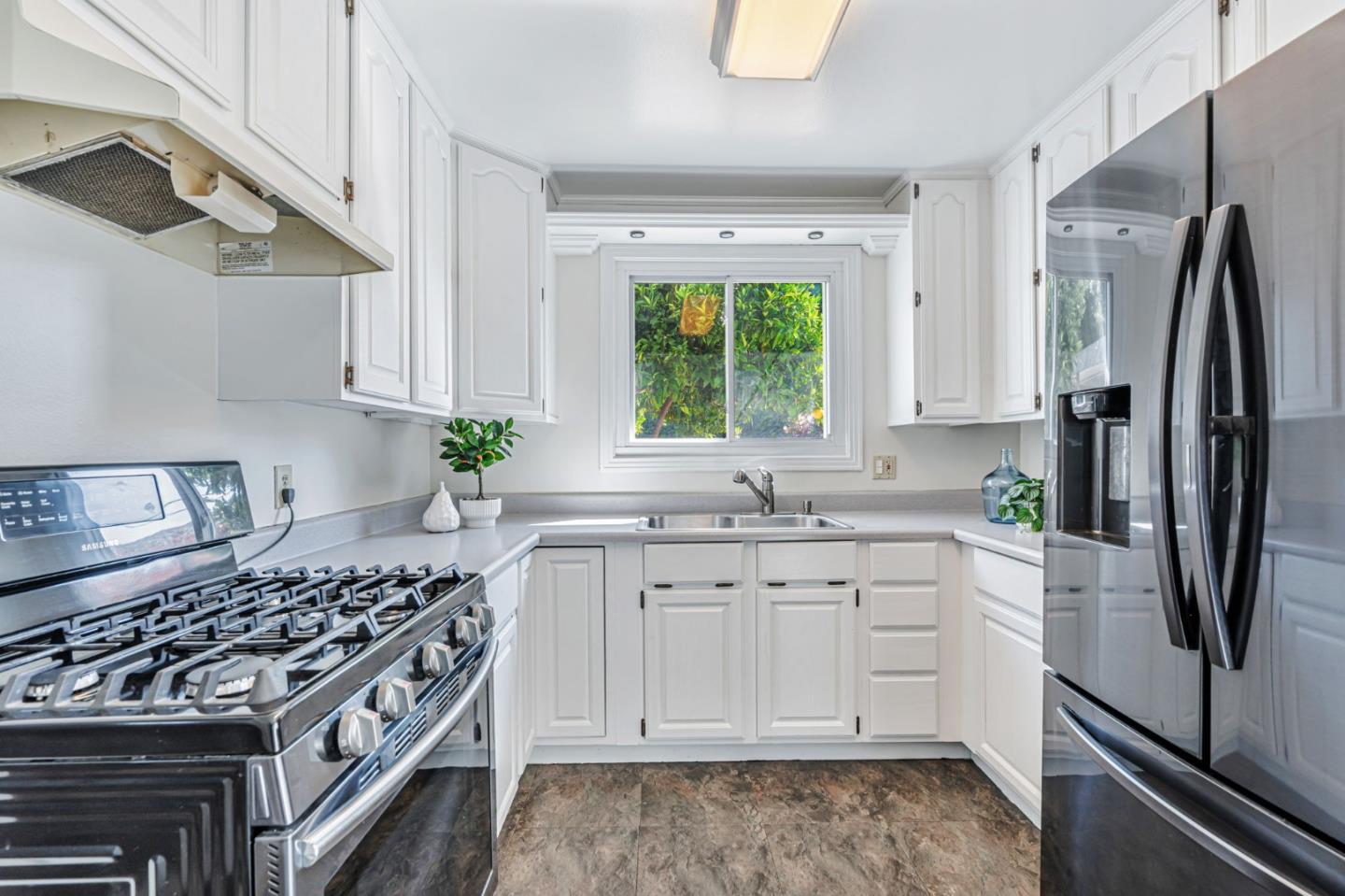 3993 Pasadena Drive San Mateo, CA 94403 - Photo 11 of 40 a kitchen with stainless steel appliances granite countertop a sink stove and refrigerator