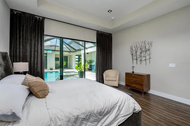 a living room with furniture a flat screen tv and a floor to ceiling window