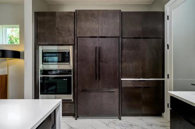 a view of a swimming pool with a lawn chairs and plants