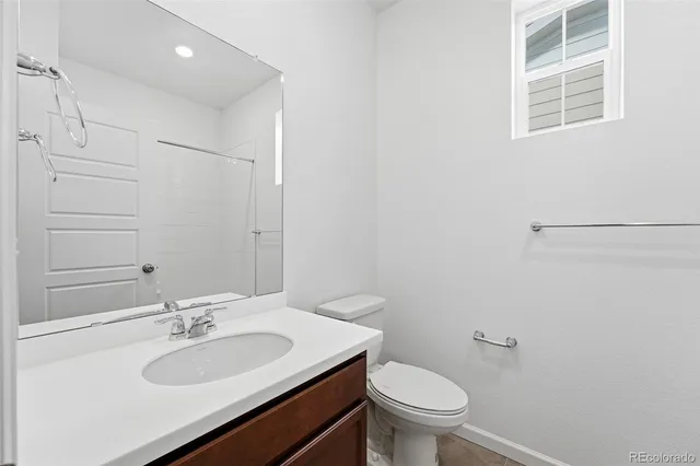 a bathroom with a sink toilet vanity and a mirror