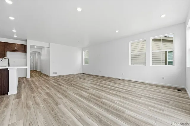 a view of empty room with wooden floor and window