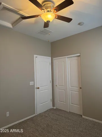 an empty room with a window and a fan