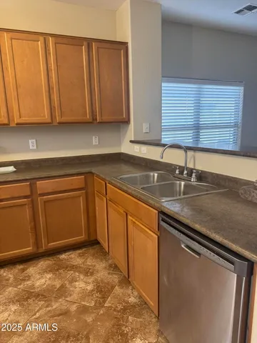 a kitchen with stainless steel appliances granite countertop a sink and a refrigerator