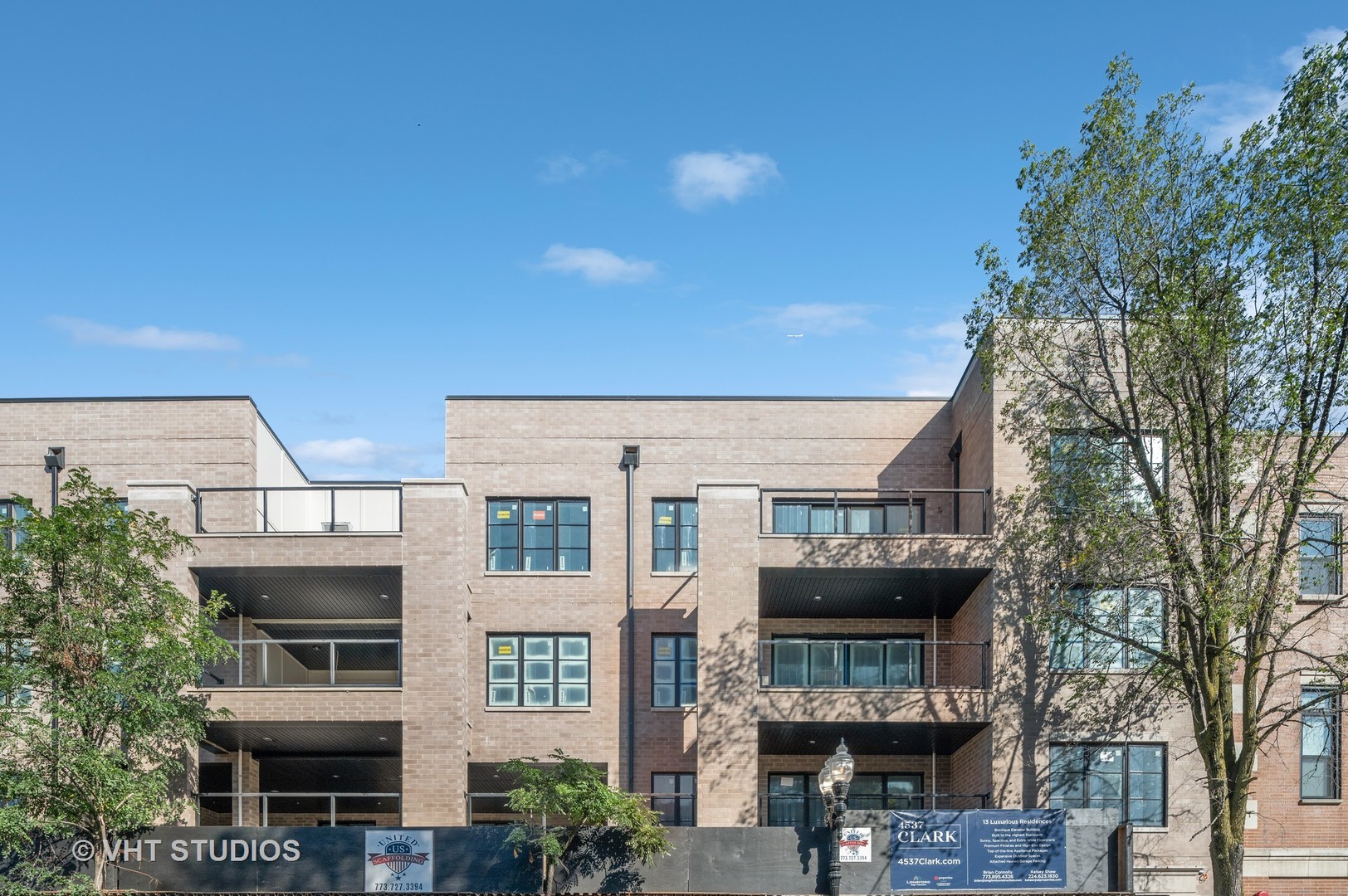 4537 North Clark Street, Unit 2D Chicago, IL 60640 - Photo 2 of 27 a front view of a building with glass windows and a tree