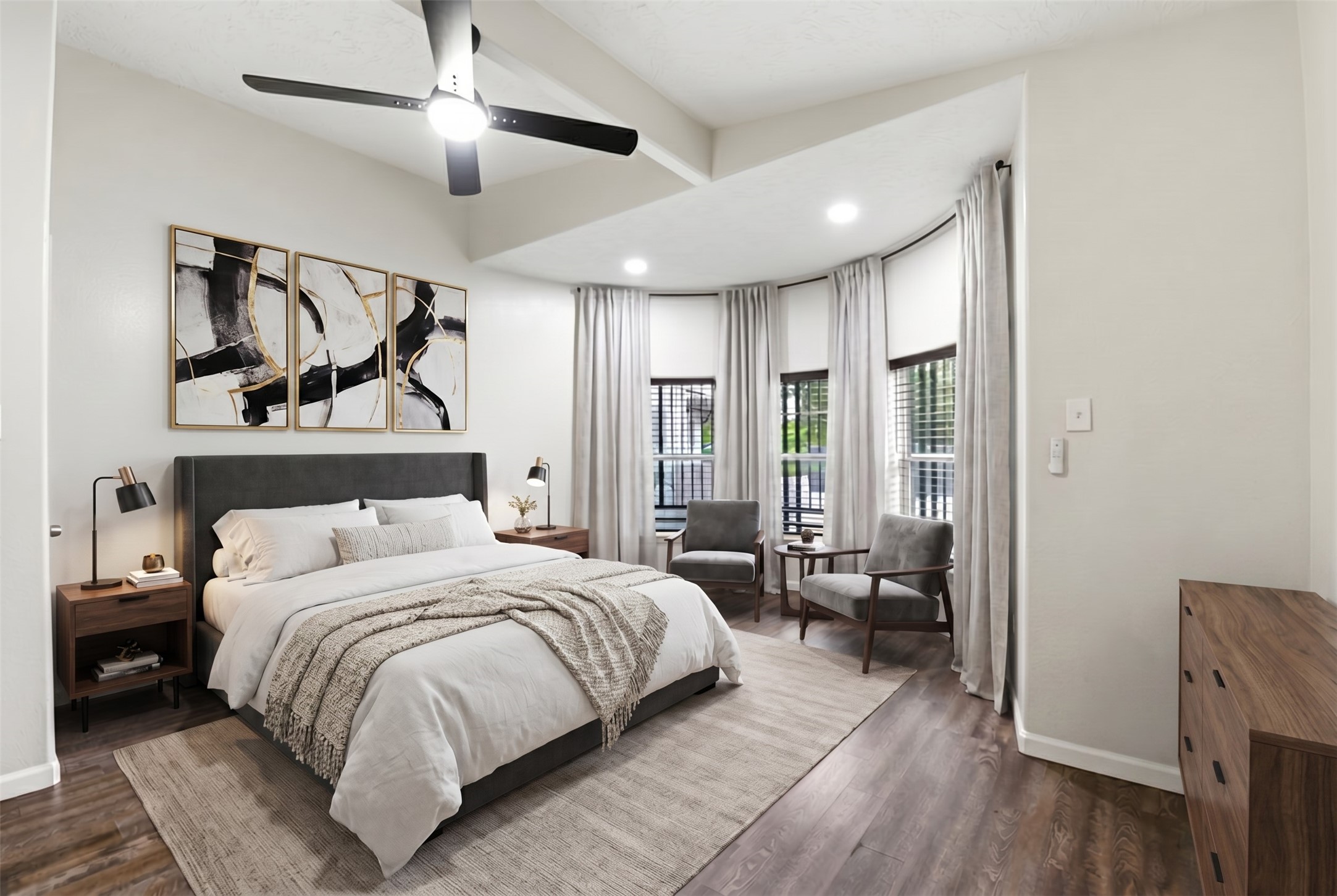 9403 Spaulding Street Houston, TX 77016 - Photo 19 of 50 This bedroom features a modern design with a spacious layout, stylish ceiling fan, and large windows with elegant curtains. It includes a comfortable bed with bedside tables, contemporary artwork, and a cozy sitting area, all set on sleek hardwood floors.
