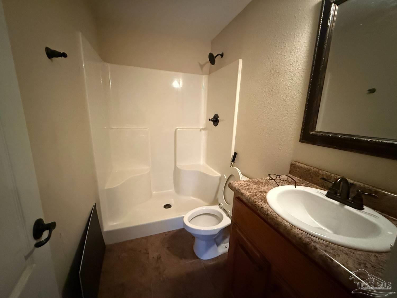 8826 Bluebell Street Milton, FL 32583 - Photo 14 of 25 a bathroom with a granite countertop sink a toilet a mirror and shower