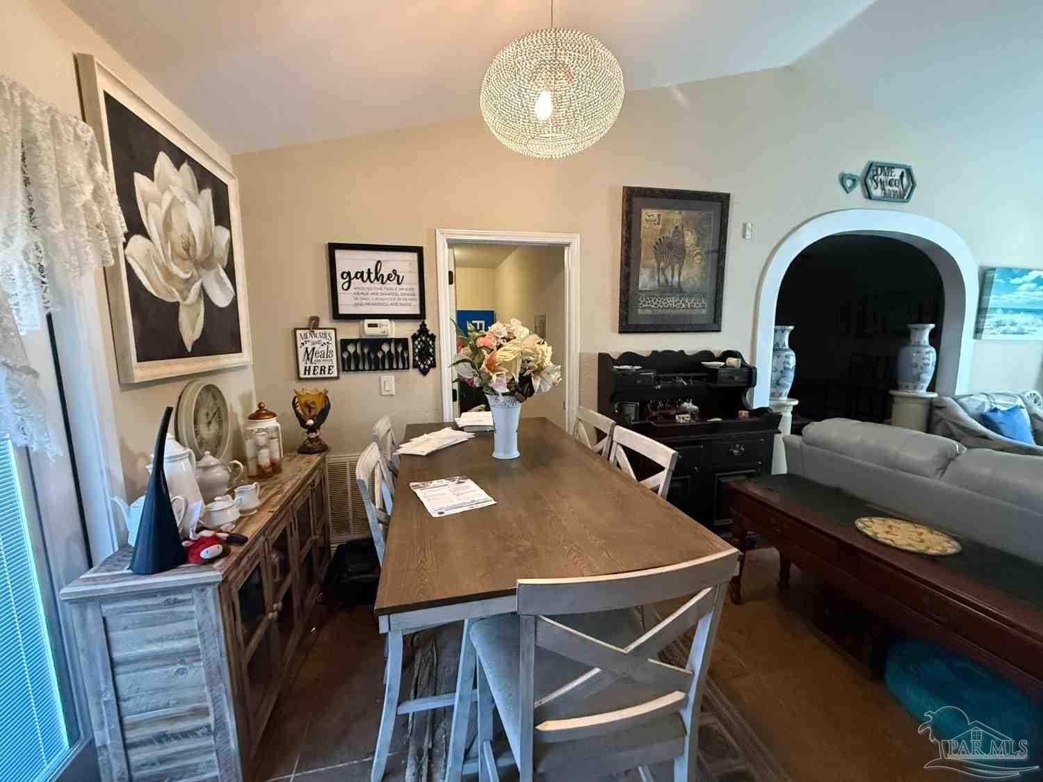 8826 Bluebell Street Milton, FL 32583 - Photo 23 of 25 a view of a dining room with furniture and chandelier