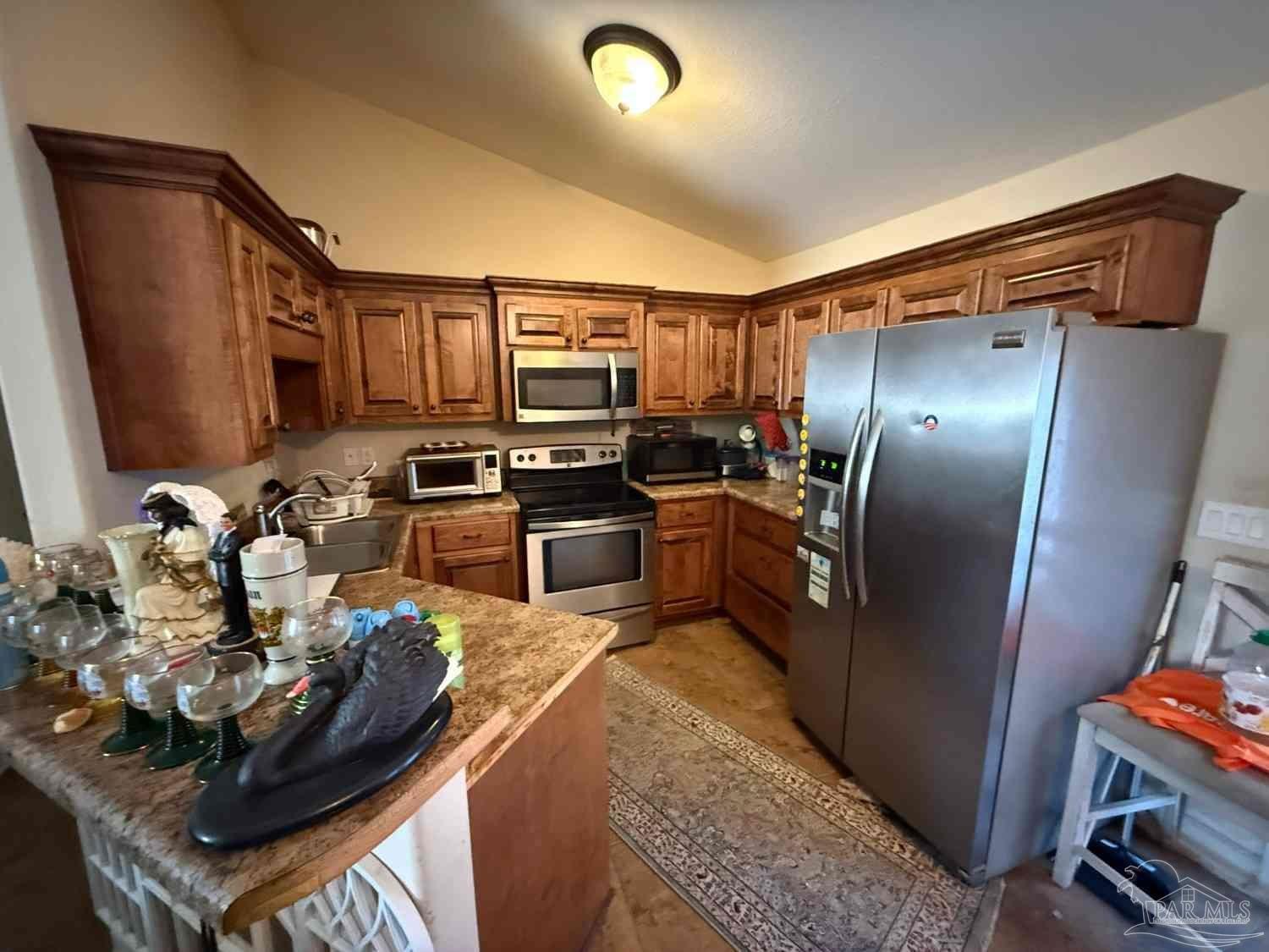 8826 Bluebell Street Milton, FL 32583 - Photo 25 of 25 a kitchen with stainless steel appliances granite countertop a sink refrigerator and stove