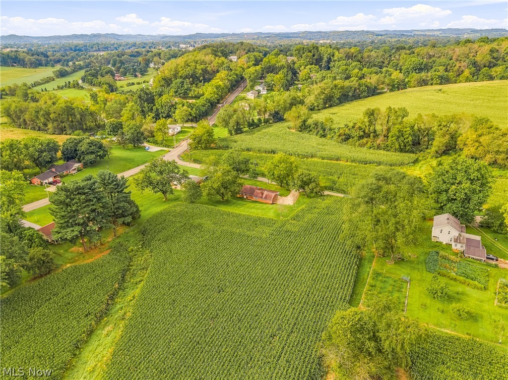 3633 Blacksnake Hill Road Northeast Dover, OH 44622 - Photo 30 of 38 Expansive agricultural landscape featuring cultivated fields, wooded hillsides, and distant residential structures