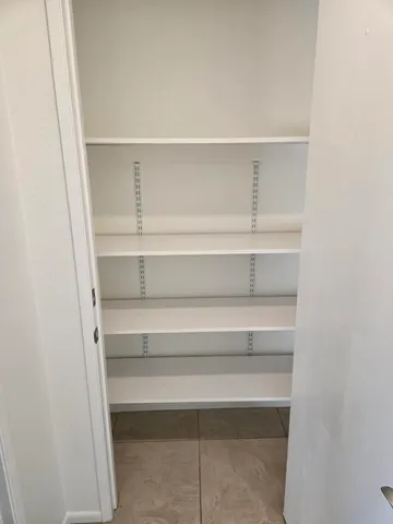 a view of walk in closet with empty racks