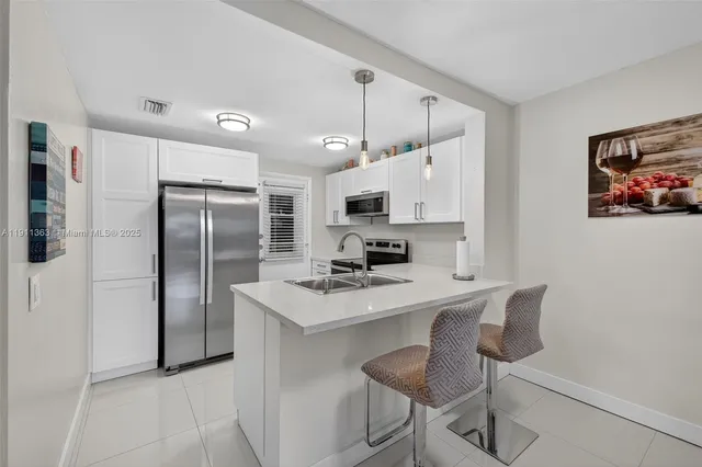 a kitchen with stainless steel appliances a refrigerator sink and microwave