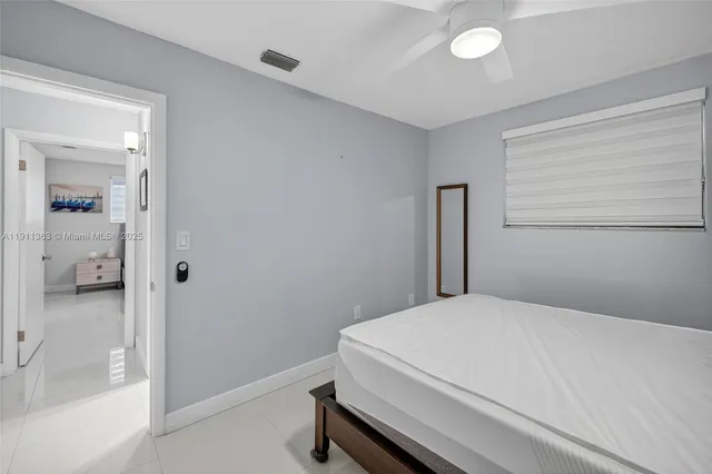 a bedroom with a bed and a refrigerator