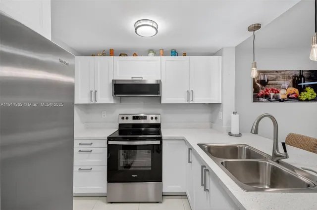 a kitchen with stainless steel appliances a sink a stove and cabinets