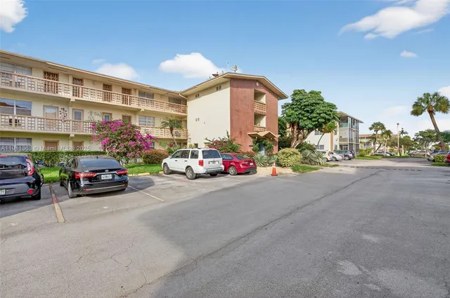 a view of a cars park in front of a building