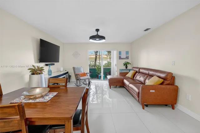 a living room with furniture a flat screen tv and a window
