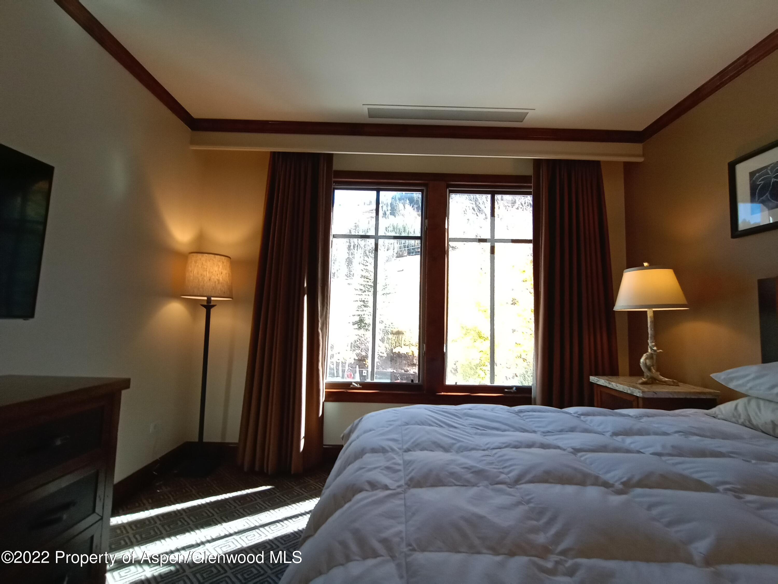 75 Prospector Road, Unit 8401 SUMMER INTEREST 9 Aspen, CO 81611 - Photo 16 of 28 a bedroom with a bed and a mirror