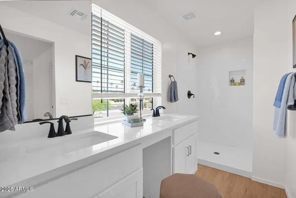a bathroom with double vanity and a bathtub