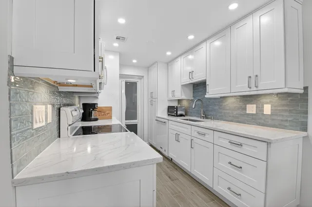 a kitchen with stainless steel appliances granite countertop a sink and cabinets