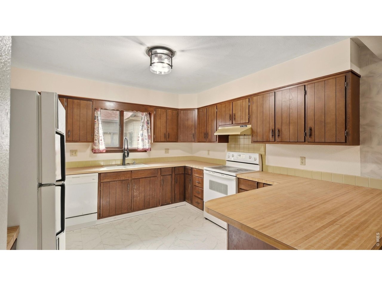 914 Prospect Street Fort Morgan, CO 80701 - Photo 6 of 17 a kitchen with stainless steel appliances granite countertop a refrigerator a sink dishwasher a stove with wooden cabinets