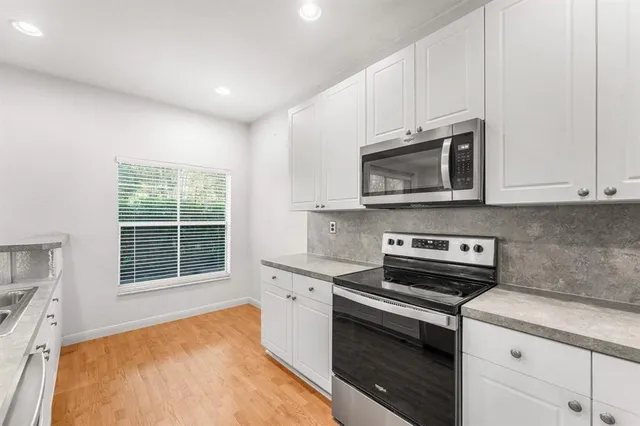 a kitchen with stainless steel appliances granite countertop a refrigerator and a sink