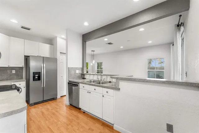 a kitchen with stainless steel appliances granite countertop a refrigerator sink and microwave