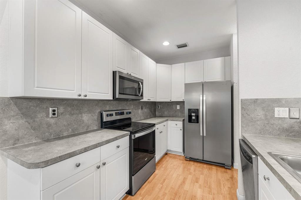 3307 Merrick Lane, Unit 1004 Margate, FL 33063 - Photo 7 of 30 a kitchen with stainless steel appliances granite countertop a refrigerator sink and microwave