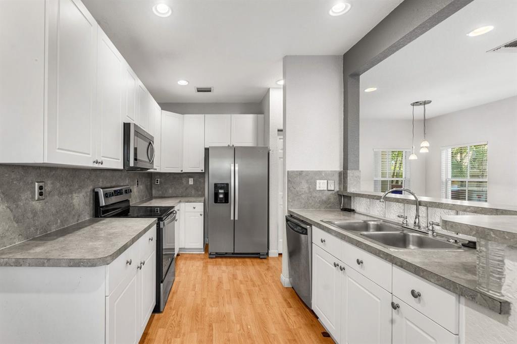 3307 Merrick Lane, Unit 1004 Margate, FL 33063 - Photo 8 of 30 a kitchen with stainless steel appliances granite countertop a sink stove and refrigerator