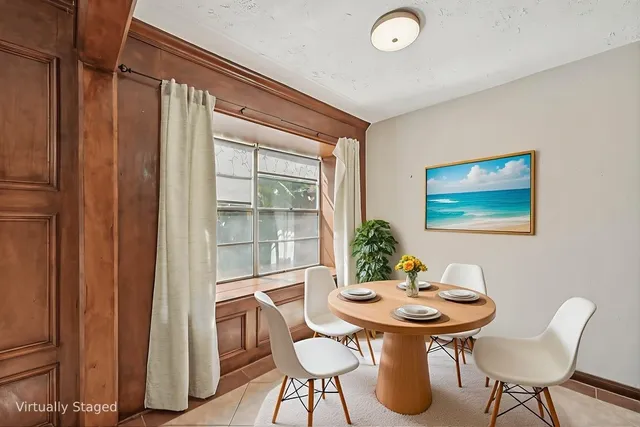 a view of a house with a yard and large tree