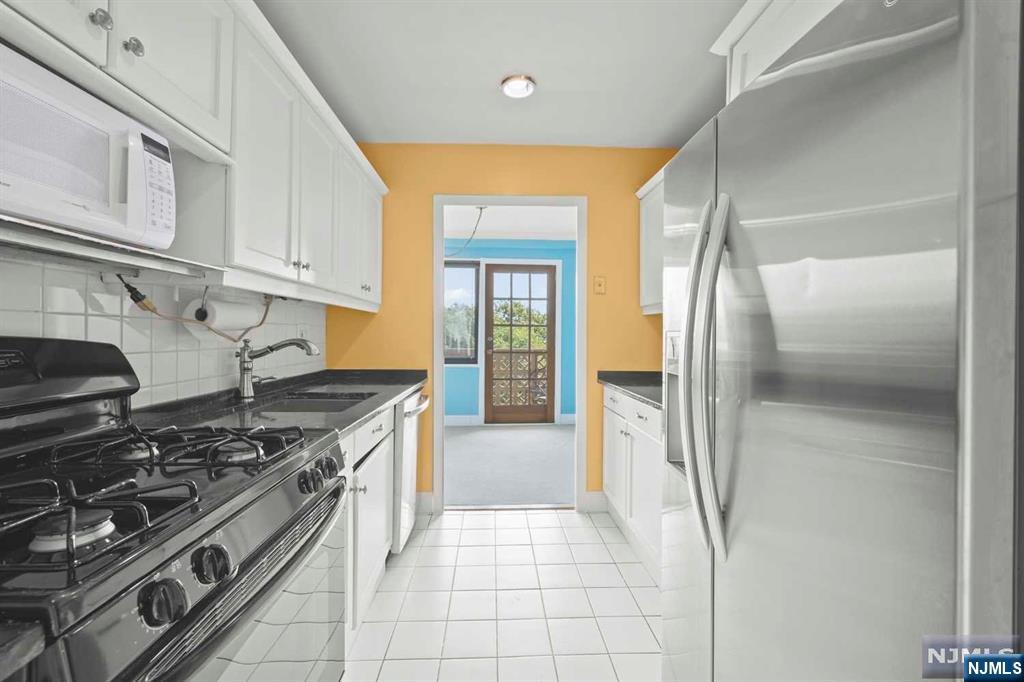 1375 River Road, Unit 4D Edgewater, NJ 07020 - Photo 17 of 25 a kitchen with stainless steel appliances granite countertop a stove and a refrigerator