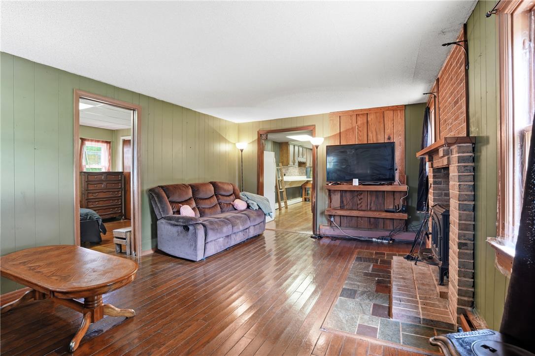 3573 Lower Saucon Road Hellertown, PA 18055 - Photo 4 of 56 Gleaming hardwood floors and a brick fireplace create a cozy, welcoming atmosphere in this spacious living area.